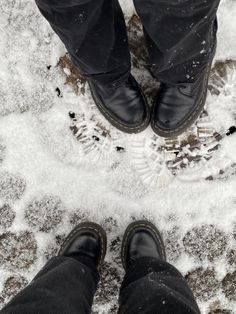 two people standing in the snow next to each other with their feet covered by snow