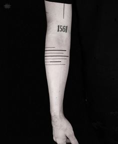 a person's arm with a tattoo on it that reads 1561 and has a line across the wrist