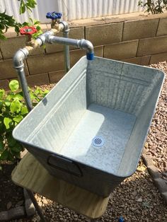 a large blue tub sitting on top of a wooden stand next to a brick wall