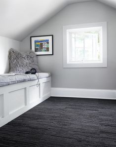 there is a window in the corner of this room with gray carpet and white walls