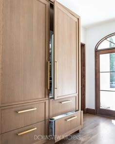 a kitchen with wooden cabinets and an arched window