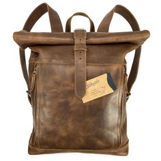 VINTAGE STYLE BACKPACK: This Roll Top Backpack is a timeless, vintage style piece handmade from durable, high quality full grain leather that is sure to last you many years and uses. Featuring two adjustable shoulder straps, you can easily find the right, comfortable fit for you. On the inside, the bag is spacious enough for your laptop and lined with beautiful plaid cotton. The two outside zipper pockets allow for quick access to your cellphone, chapstick, wallet, pen or other small valuables. Vintage Rectangular Leather Backpack With Adjustable Strap, Vintage Leather Backpack With Adjustable Strap, Retro Leather Backpack With Adjustable Strap, Retro Leather Travel Backpack, Vintage Leather Backpack With Adjustable Strap For Adventure, Vintage Backpack With Leather Lining For Everyday Use, Vintage Backpack With Adjustable Strap For Adventure, Vintage Rectangular Backpack With Leather Lining, Vintage Everyday Backpack With Leather Backing