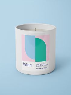 a white candle with a blue and pink design on the inside, sitting in front of a light blue background