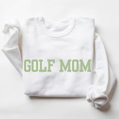 Golf Mom Sweatshirt I love to help my customers with custom orders! I am happy to help you with color changes, text modifications, or another idea that you have. Please add you personalization request in the box when you check out or feel free to send me a message! I will get back to you promptly. Here is the link to my other golf apparel & gifts: https://www.etsy.com/shop/ALittleSprinkl?ref=seller-platform-mcnav&section_id=48949416 This is a Gildan Sweatshirt with a UNISEX FIT. Please review the size chart in the images before you place your order. If you have any questions about sizing, I would be happy to help! If you don't see the specific color that you are looking for, please message me and I will get back to you quickly. PRODUCTION and SHIPPING Production takes about 1-3 days and st Customizable White Team Spirit Sweatshirt, White Team Spirit Customizable Sweatshirt, Customizable White Sweatshirt For Sports, White Customizable Sweatshirt For Sports, White Letter Print Sweatshirt For Gift, White Letter Print Sweatshirt As Gift, Customizable White Sweatshirt For Game Day, Customizable White Sweatshirt For Sports Events, Customizable White Crew T-shirt