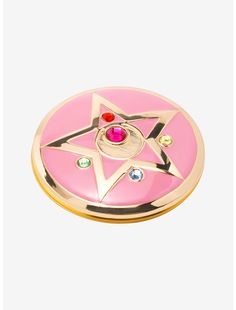 a pink and gold plate with a star design on the center, surrounded by multi - colored stones