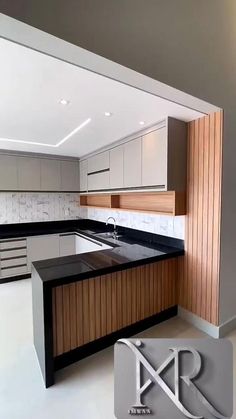 an empty kitchen with black counter tops and wooden cabinets in the center, along with white tiles on the walls