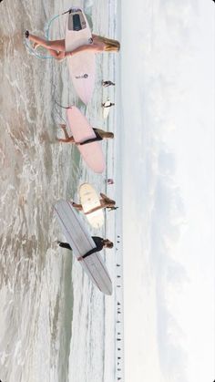 two people standing on the beach with surfboards in their hands and one person holding a surfboard