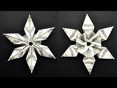 two origami snowflakes made out of dollar bills on a black background