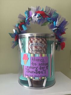 an ice cream bucket is decorated with colorful paper and some stickers that say happy birthday