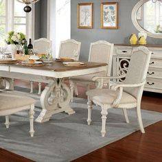 a dining room table with chairs and a mirror on the wall in front of it