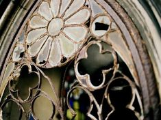 an ornate iron window frame with flowers on it