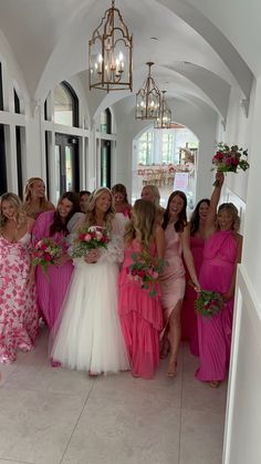 a group of women in pink dresses posing for a photo