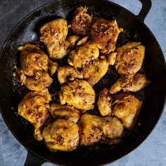 chicken wings cooking in a skillet on a table