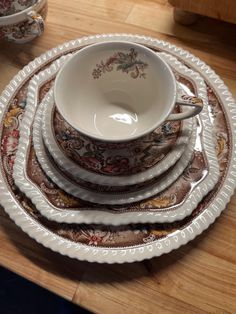 a stack of plates and bowls sitting on top of a wooden table