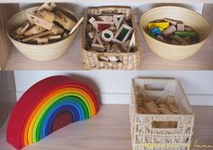 there are several baskets and toys on the shelves in this room, one is filled with wooden pegs