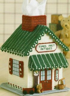 a small white building with a green roof and red trim on it's side