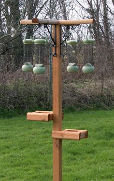 a wooden bird feeder on top of a green field