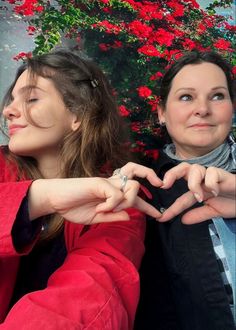 two women making the shape of a heart with their hands