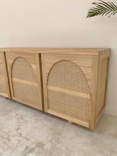 a wooden sideboard with two speakers on the front and one is made out of rattan