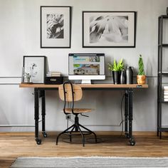 a desk with a computer on top of it next to a chair and bookshelf