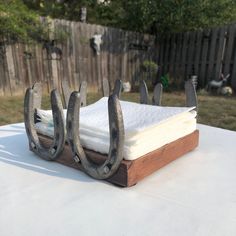 an open book on top of a wooden stand with two iron horseshoes attached to it