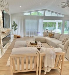 a living room filled with furniture and a flat screen tv mounted on a wall above a fireplace