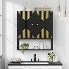 a bathroom with black and gold decor on the cabinet above the sink in front of a window