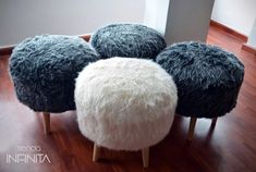 four black and white stools sitting on top of a wooden floor