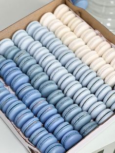 a box filled with blue and white macaroons