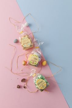 three soaps wrapped in cellophane on a pink and blue background