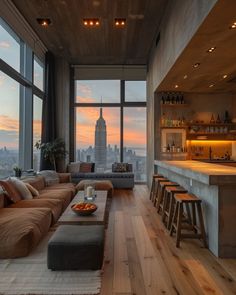 a living room filled with furniture next to a tall window covered in lots of windows