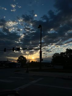 the sun is setting behind some clouds in the sky