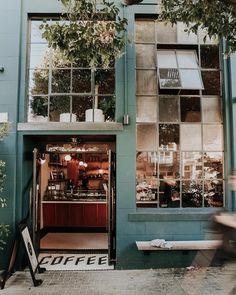 a coffee shop on the corner of a street in front of a building with lots of windows