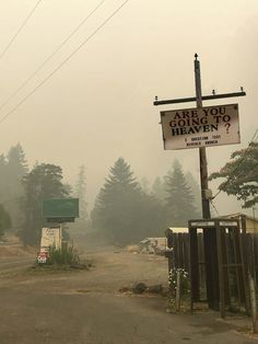 a sign that is on the side of a road with trees in the back ground