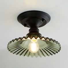 a light that is on the ceiling with a white wall in the back ground behind it