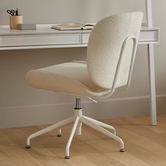 an office chair sitting in front of a desk with a book on top of it