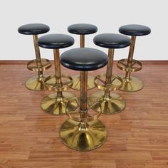 four black and gold stools on wooden floor