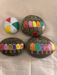 three painted rocks with the words hello summer written on them