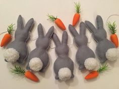 four stuffed rabbits with carrots attached to them