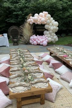 a table set up for a party with pink and white balloons