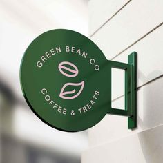 the green bean co coffee and treats sign is on the side of a white building