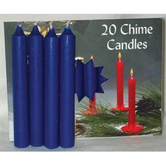 four blue candles with red wax and gold trimmings in front of a christmas card