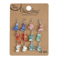 four charms are hanging from a card with the words charmions on it's side