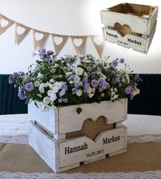 a wooden box filled with flowers sitting on top of a table next to a bunting banner