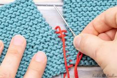 two hands are working on a crochet project