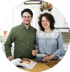 a man and woman standing next to each other in front of a kitchen counter top