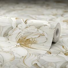 a close up of a flower on a bed with white and gold wall coverings