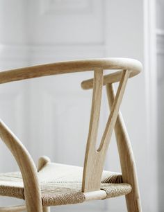 a wooden chair sitting on top of a hard wood floor next to a white wall