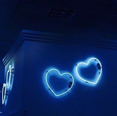 two heart shaped neon signs on the side of a building