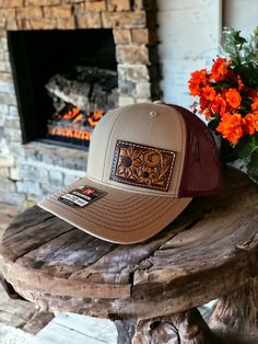 Mid trucker hat with one of a hand tooled leather patch. Patch features floral carving and sunflowers. Hat is SnapBack adjustable and is red and khaki tan in color. PLEASE READ: This item is for pre-ordering, and is made to order! Once purchased, this item will take approximately two weeks to re-create. Item will be a close replica, but each one will have slight variances in color, carving, etc. as I am not perfect, and leather is not perfect either! Brown Curved Brim Baseball Cap For Rodeo, Adjustable Brown Leather Baseball Cap, Brown Baseball Cap For Rodeo, Western Style Brown Flat Bill Baseball Cap, Western Trucker Hat With Leather Patch, Brown Rodeo Hat With Leather Patch, Western Style Adjustable Trucker Hat With Leather Patch, Adjustable Brown Baseball Cap For Rodeo, Western Brown Hat With Leather Patch